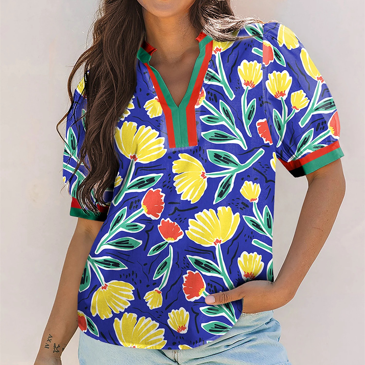 Women's blue floral print pullover top with V-neckline, short sleeves, and contrasting botanical design